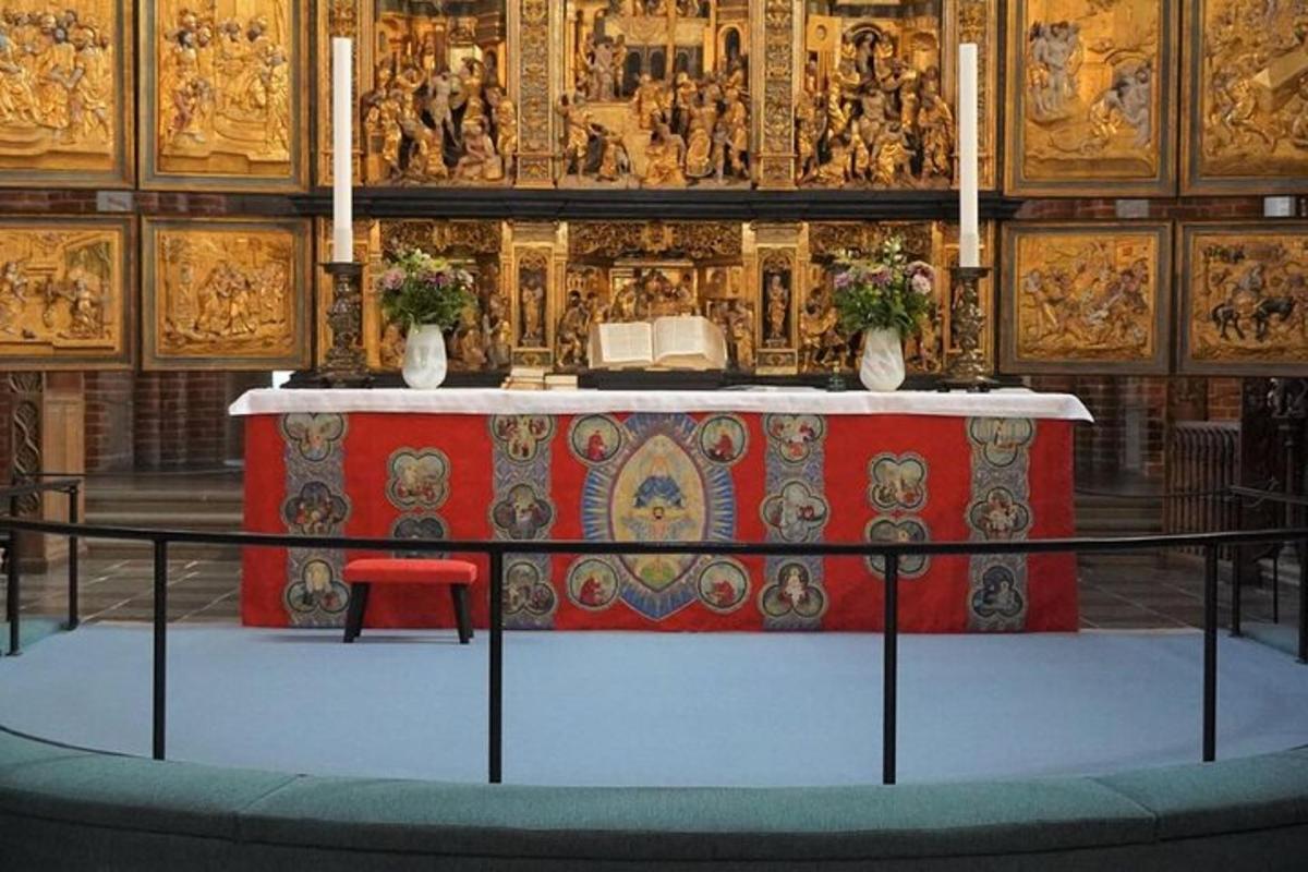 un altare in una chiesa con un tavolo con una tovaglia rossa