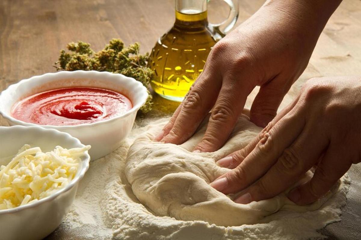osoba hněte těsto na stole s ingrediencemi