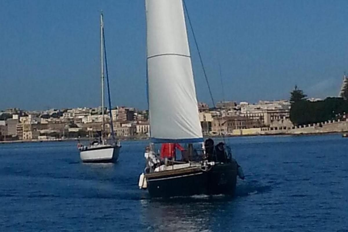 zwei Boote im Wasser mit einer Stadt im Hintergrund
