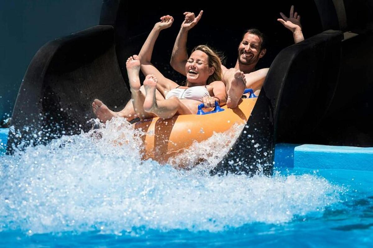 two people riding on an orange raft in the water