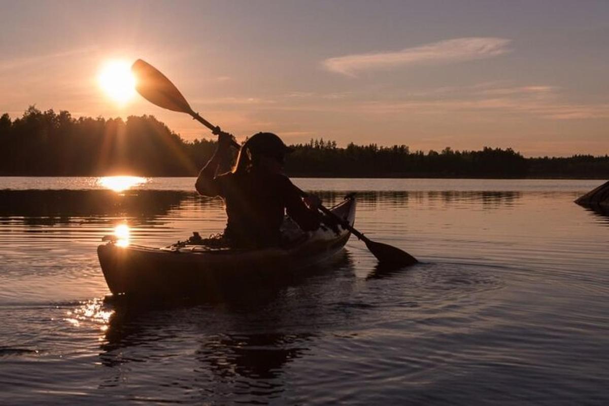 a person in a kayak on a lake at sunset