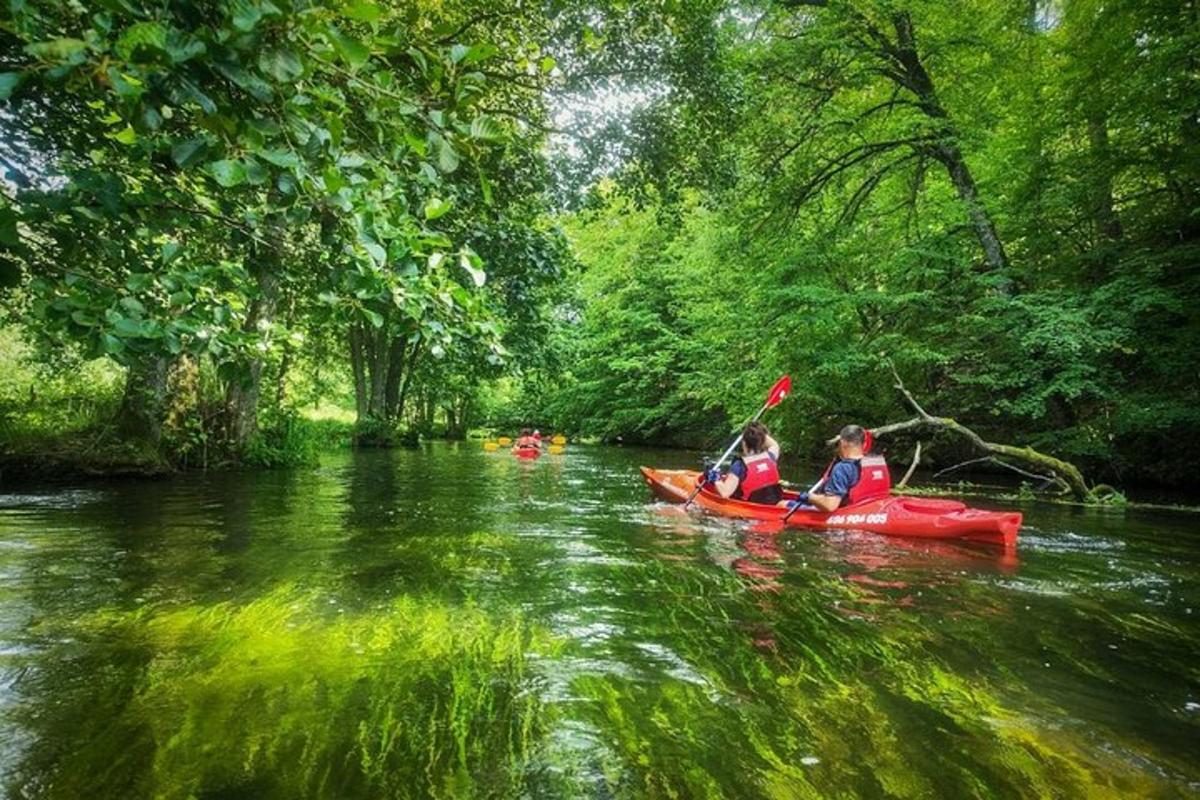 two people in a red kayak on a river