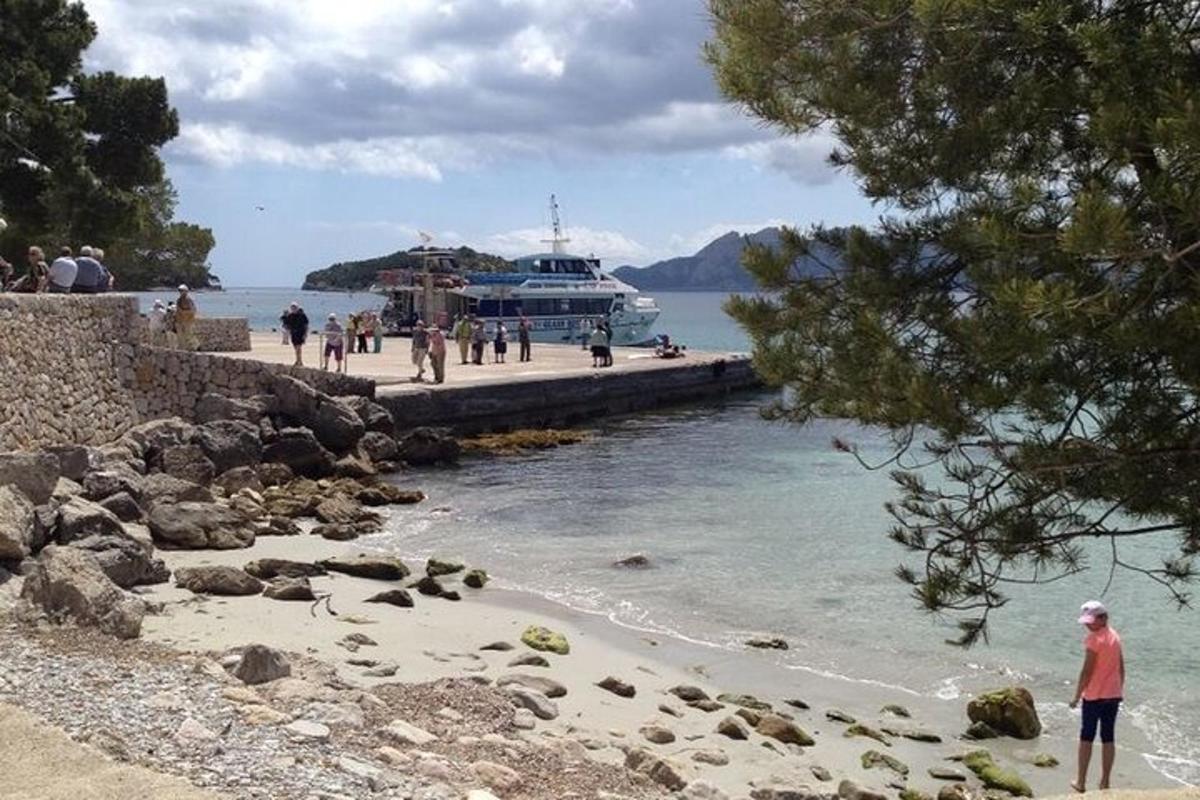 a group of people standing on a beach with a boat