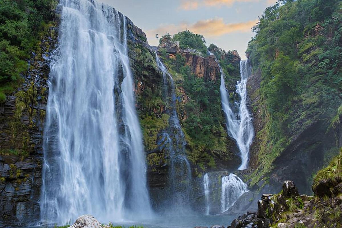 Una cascada en una montaña con agua saliendo de ella.