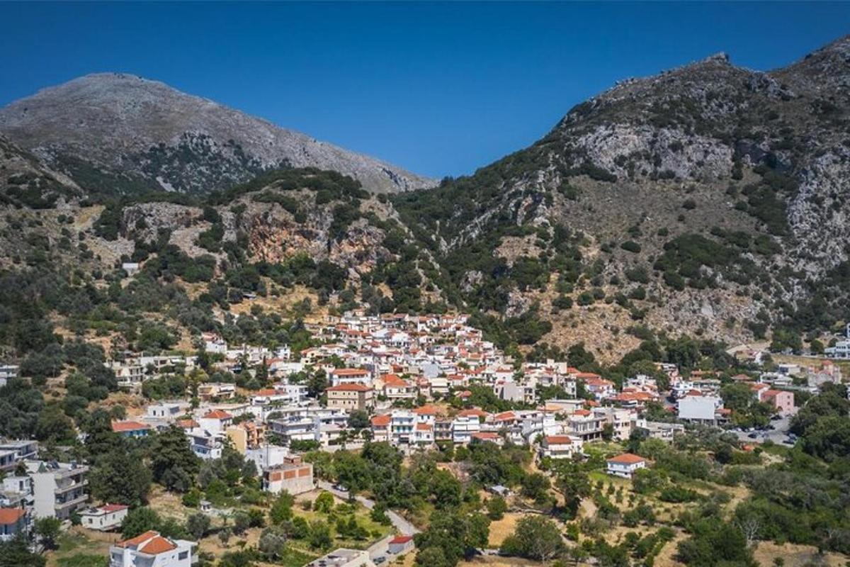 μια πόλη σε έναν λόφο με βουνά στο φόντο