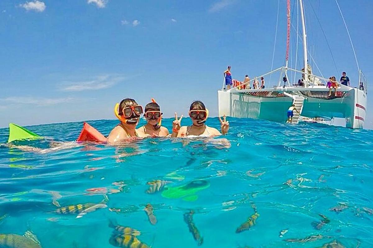 tres personas en el agua delante de un barco