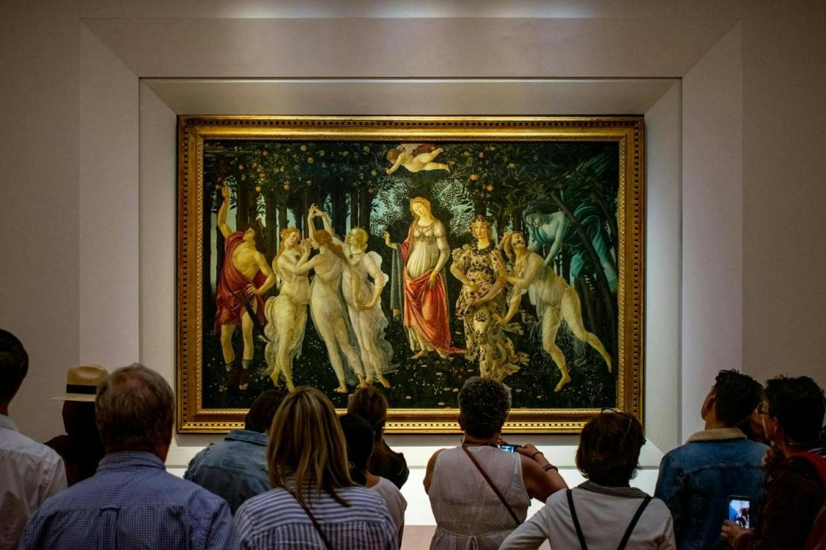 tłum ludzi oglądających obraz w muzeum