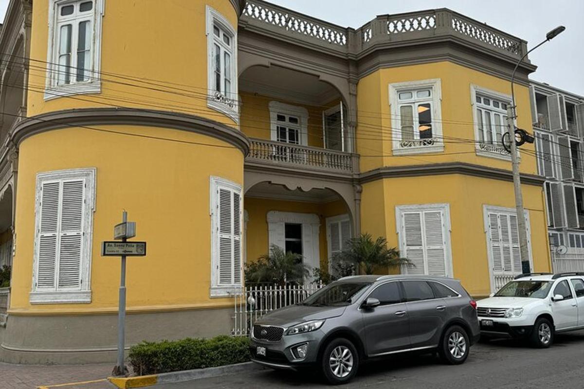 o casă galbenă cu două mașini parcate în fața ei