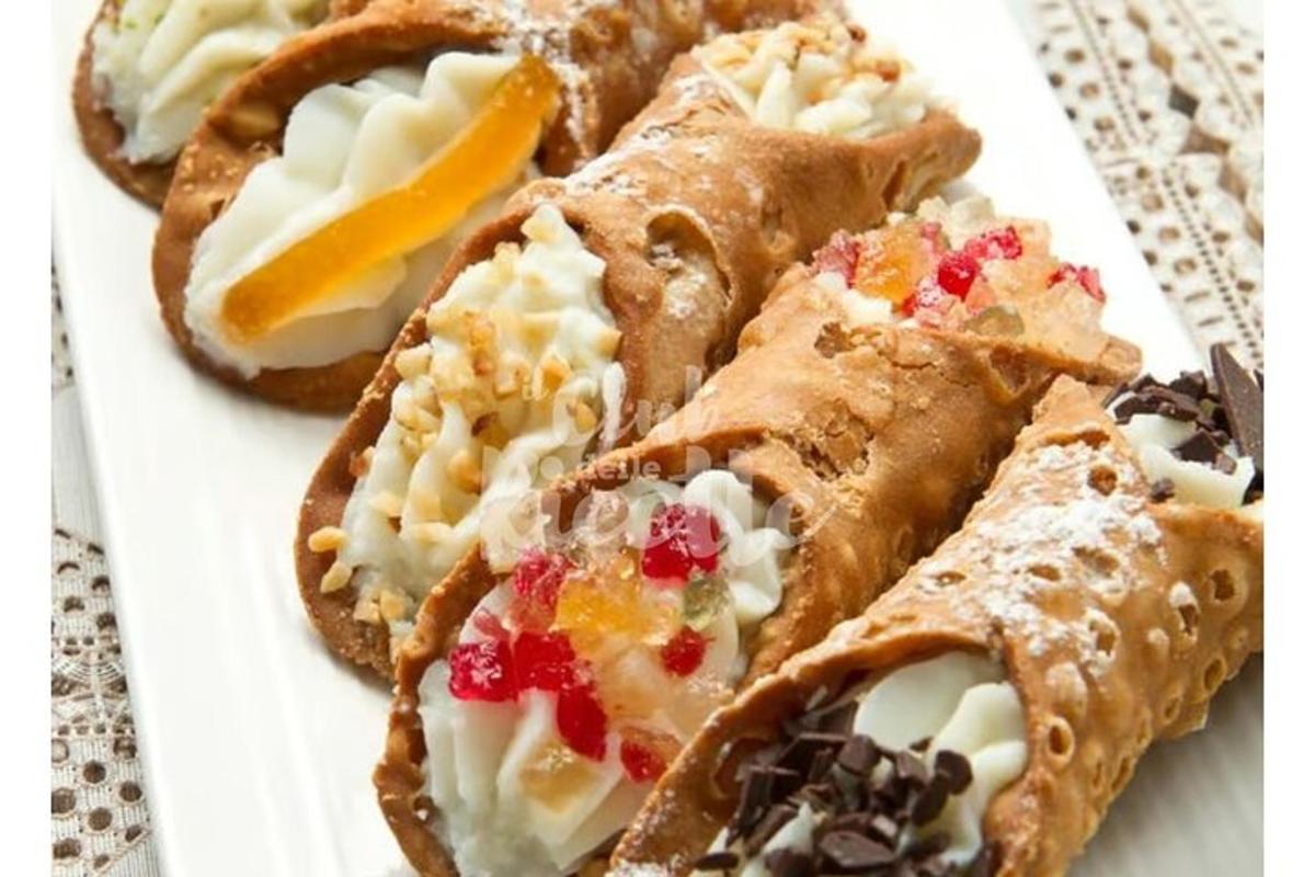 isang puting plato na may tatlong pastry sa isang mesa