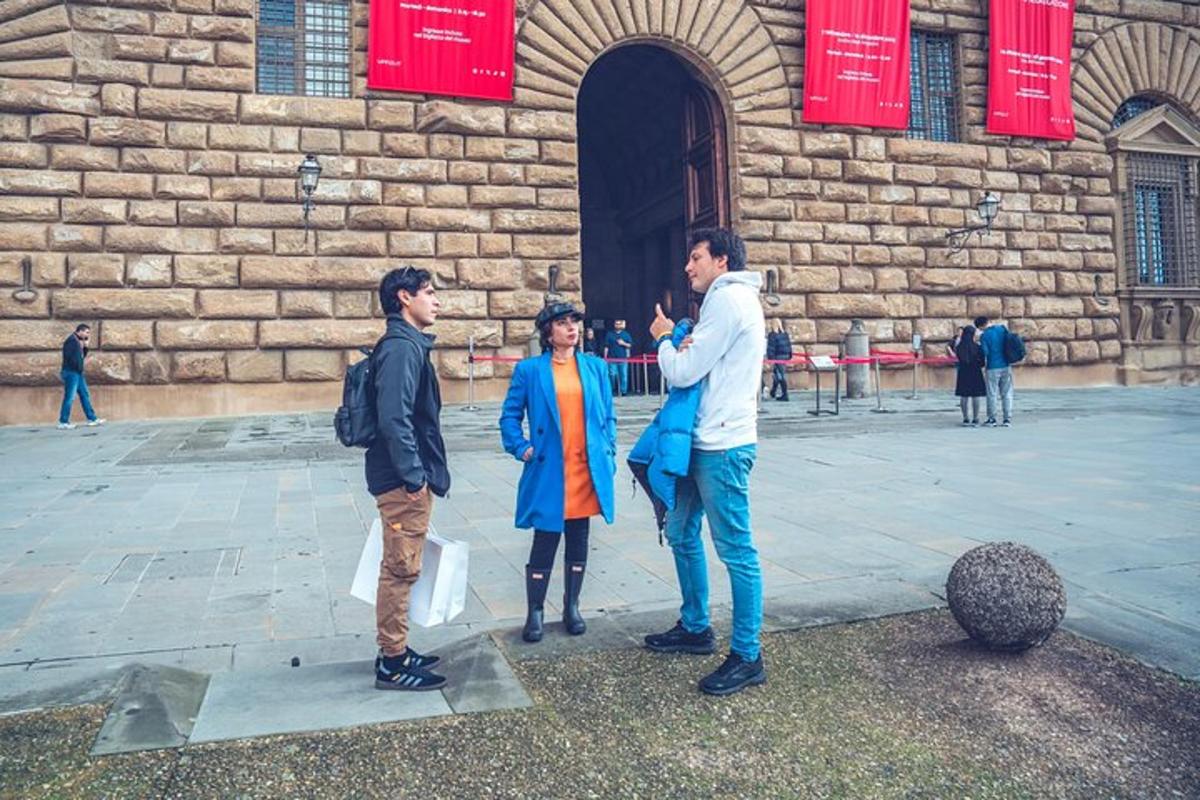 un grup de tres persones dretes davant d'un edifici