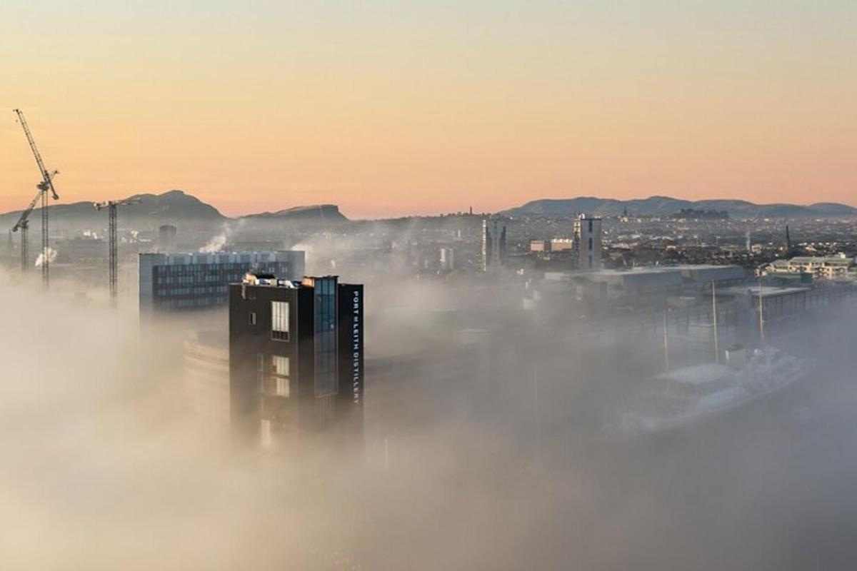 una città avvolta nella nebbia con edifici e un mulino a vento