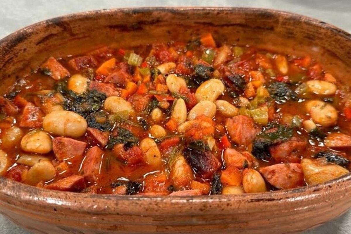 a wooden bowl of stew with vegetables in it