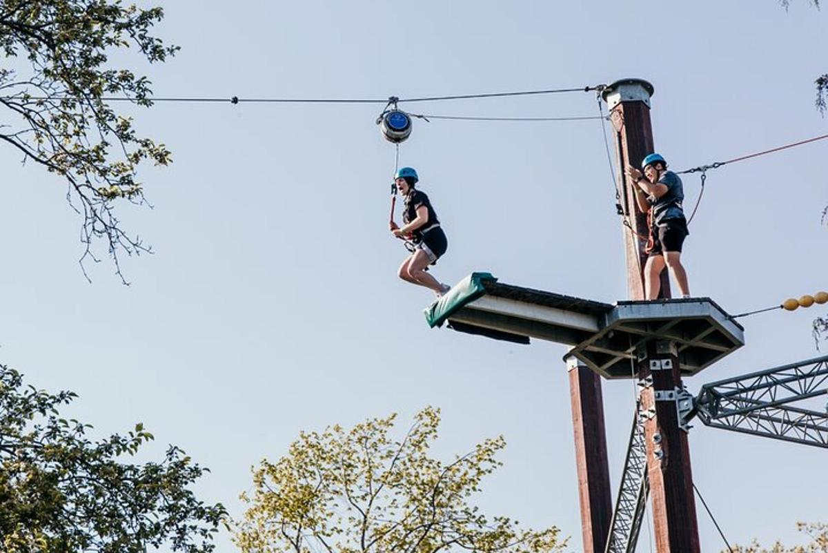 two people on a zip line in the trees