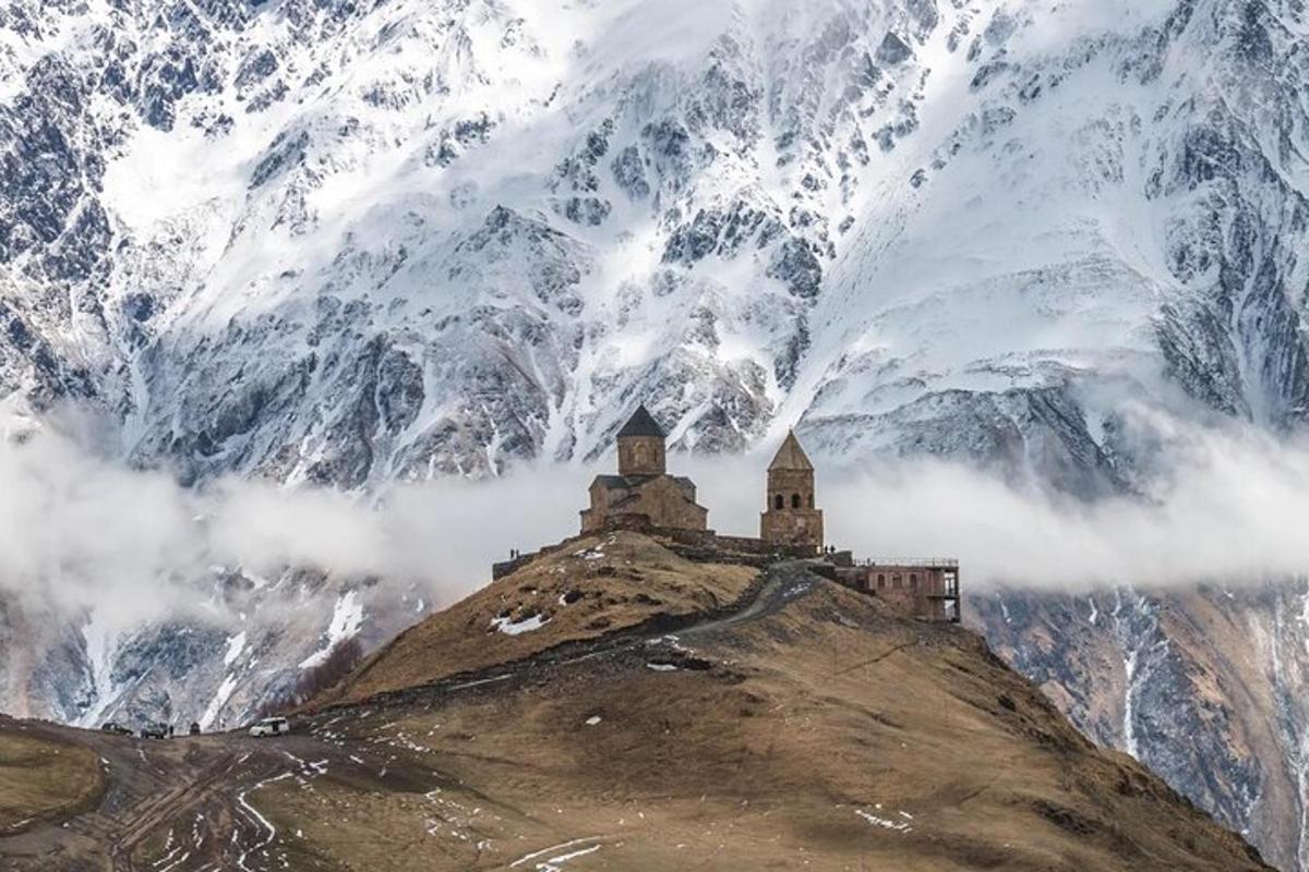un castell al cim d'una muntanya amb muntanyes cobertes de neu