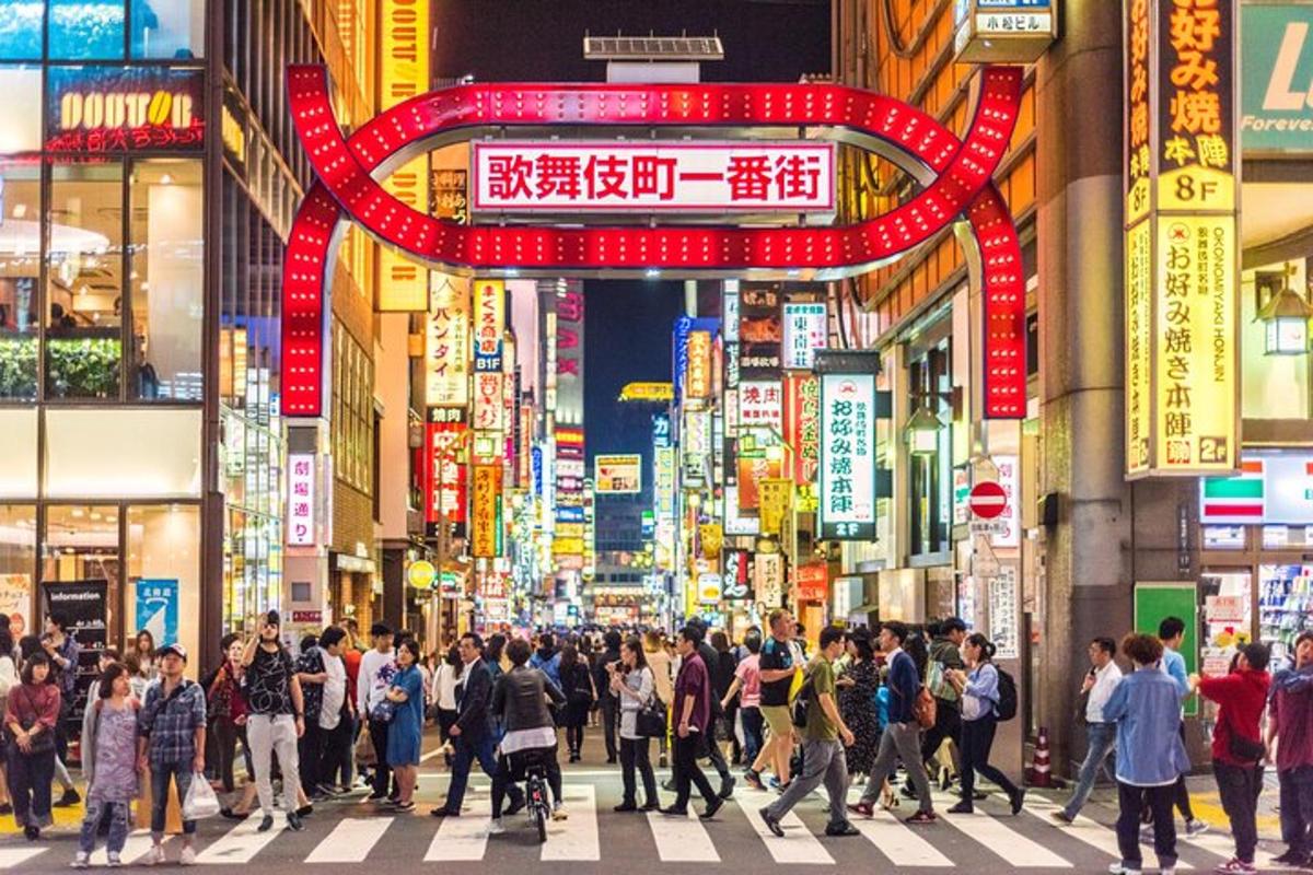 a crowd of people crossing a street in a busy city