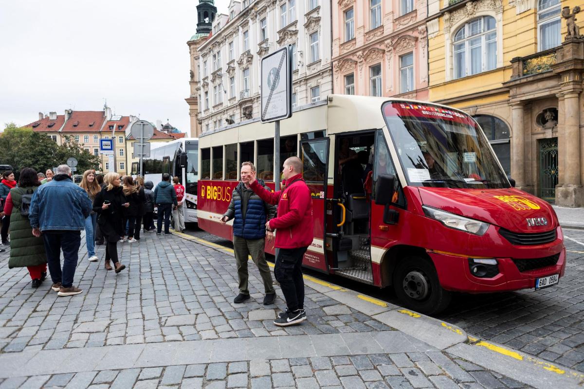 hópur fólks sem stendur fyrir framan strætó
