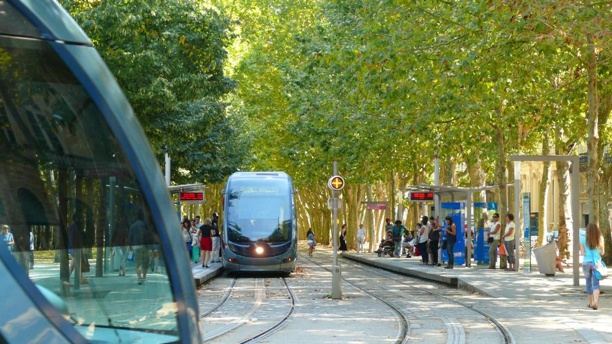 a blue train is on the tracks at a train station