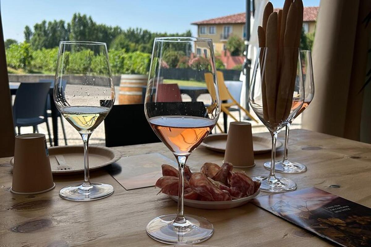 três taças de vinho sobre uma mesa com um prato de comida