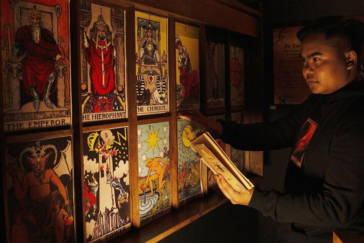 um homem parado em frente a uma parede de pinturas