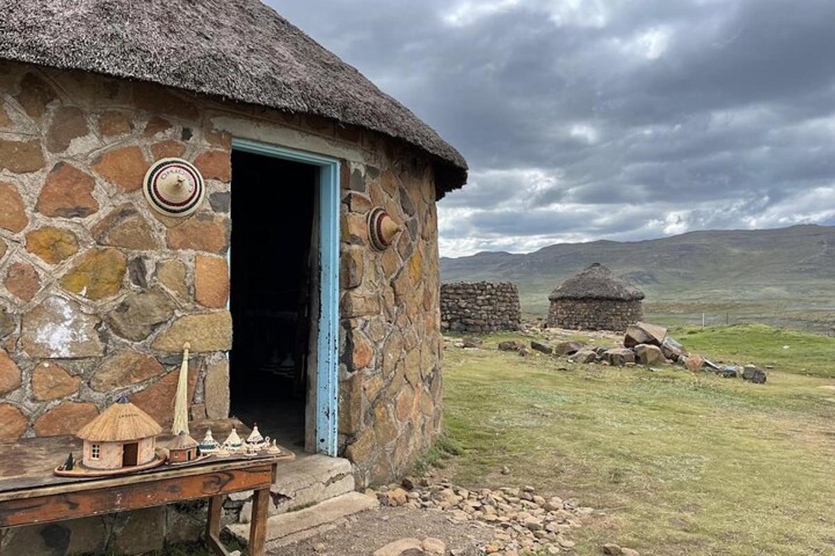 a stone building with a door open on a field