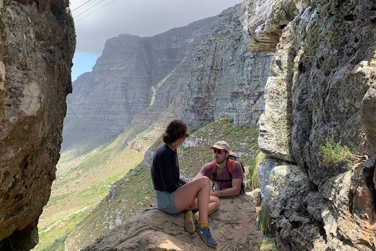 Dos personas sentadas en una roca en las montañas.