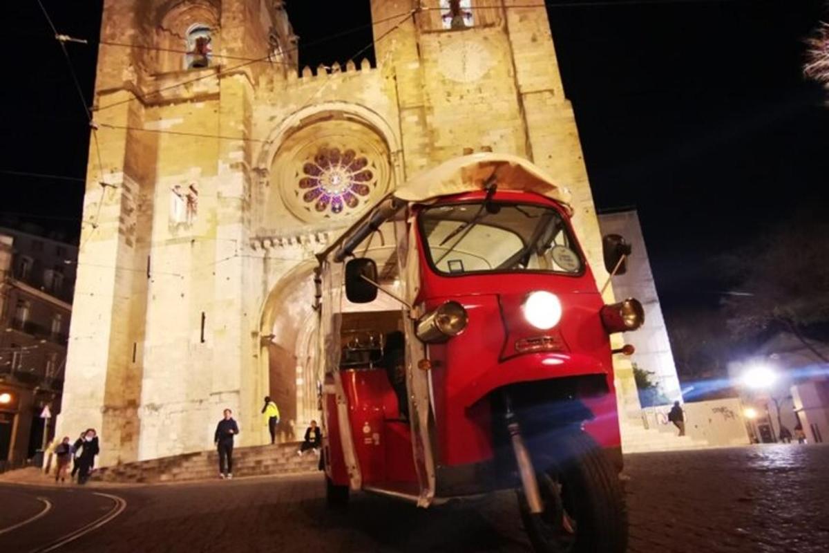 una piccola macchina rossa parcheggiata davanti a un edificio
