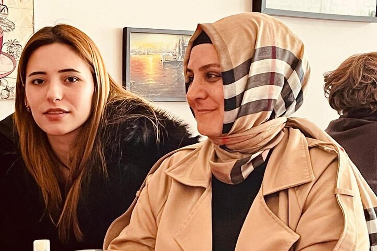 ženska s hidžabom sedi poleg druge ženske