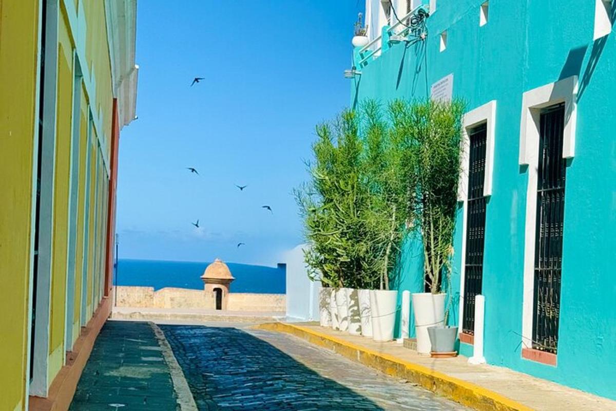 una strada stretta con un edificio blu e l'oceano