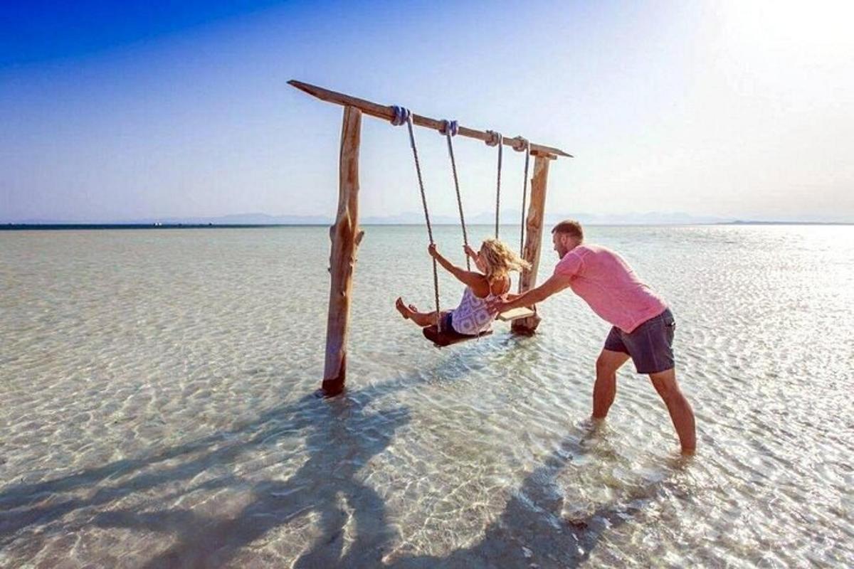 un bărbat și o femeie pe un leagăn pe plajă