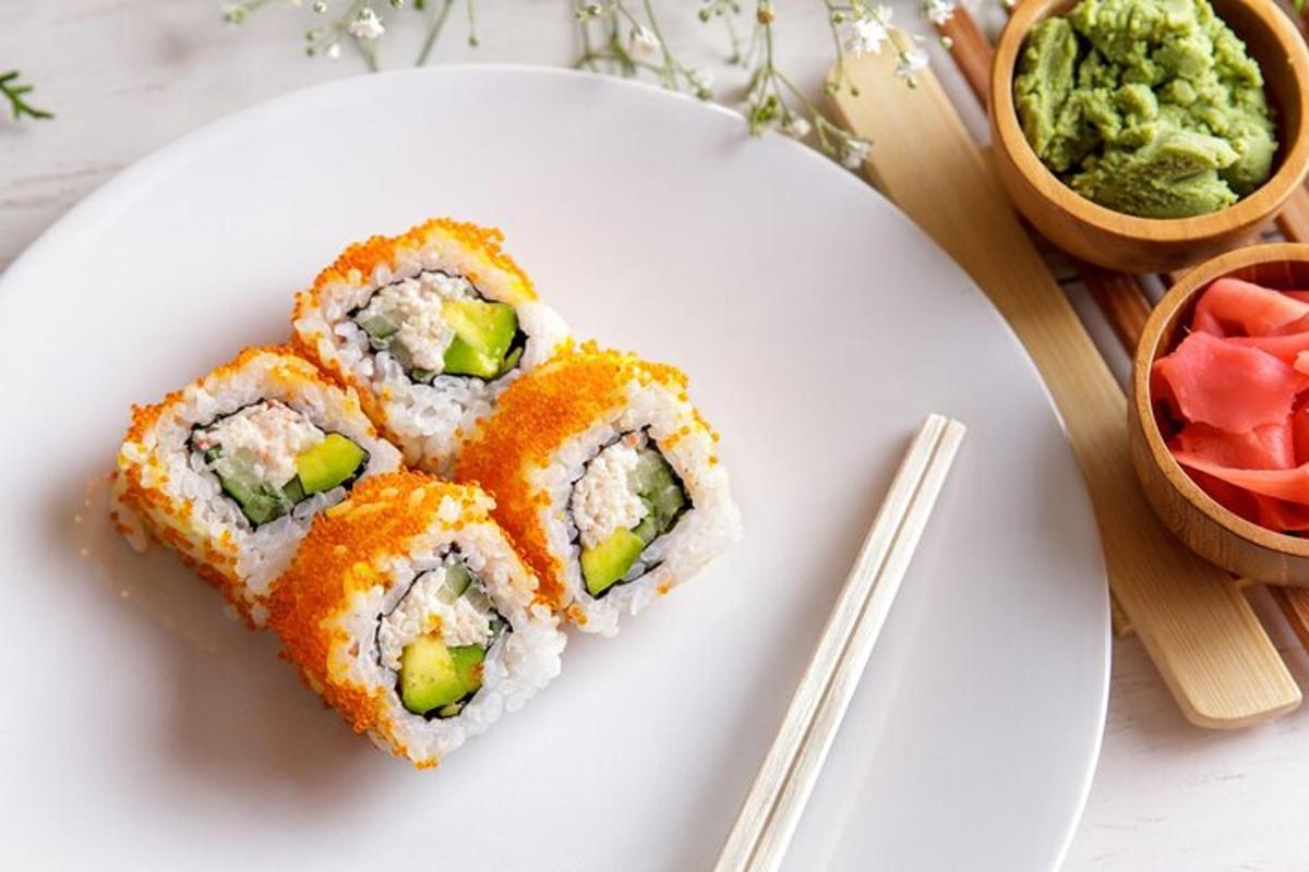 a white plate with sushi on it with chopsticks