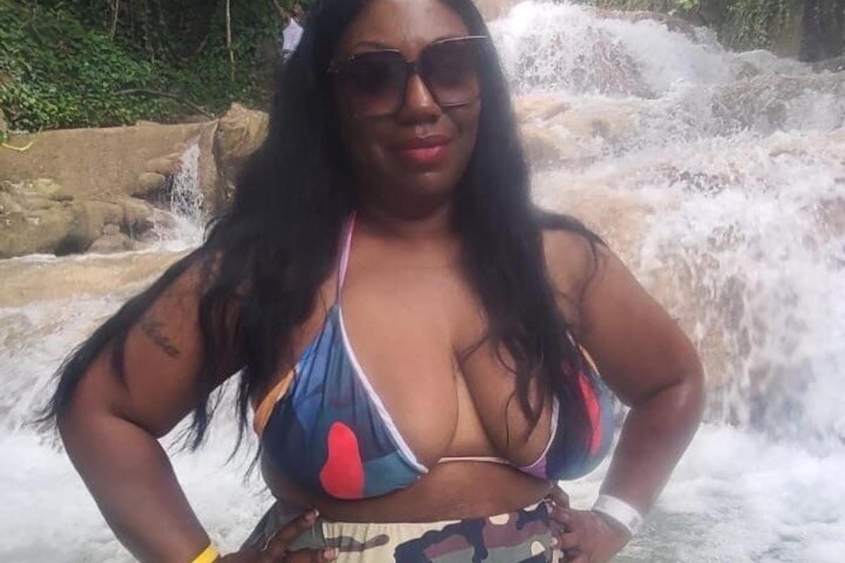 una dona en bikini davant d'una cascada
