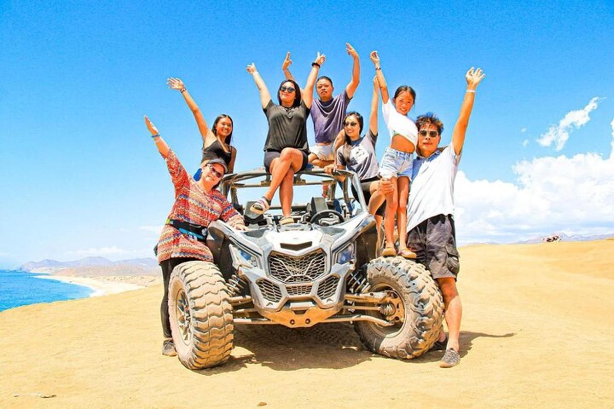 a group of people sitting on a four wheeler on the beach