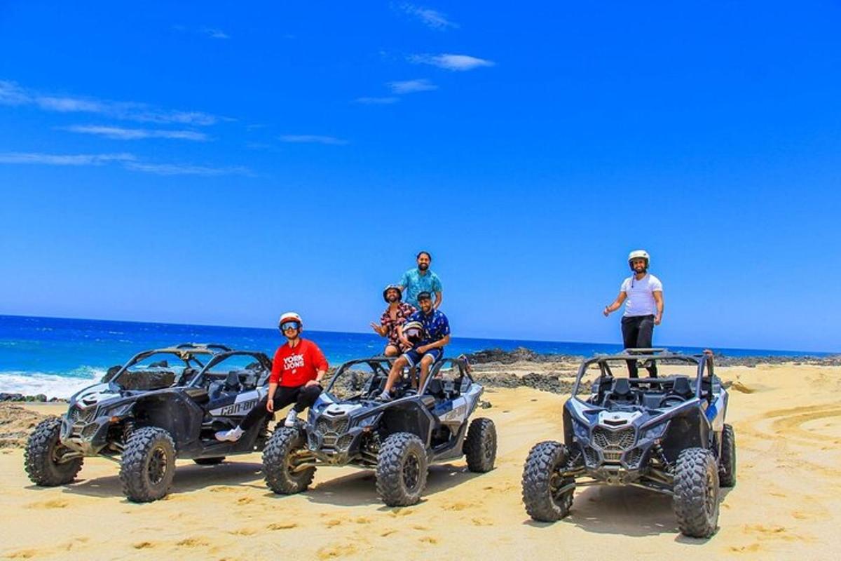 skupina ljudi, ki sedijo v štirikolesnikih na plaži