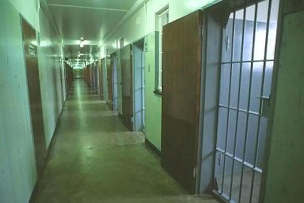 prazan hodnik zatvorske ćelije sa zelenim vratima