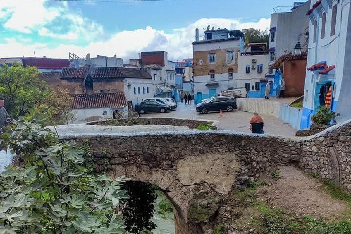 eine alte Steinbrücke über eine Straße in einer Stadt