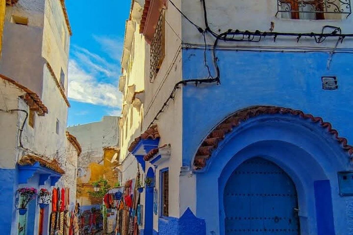 ein blau-weißes Gebäude mit einem Tor in einer Straße