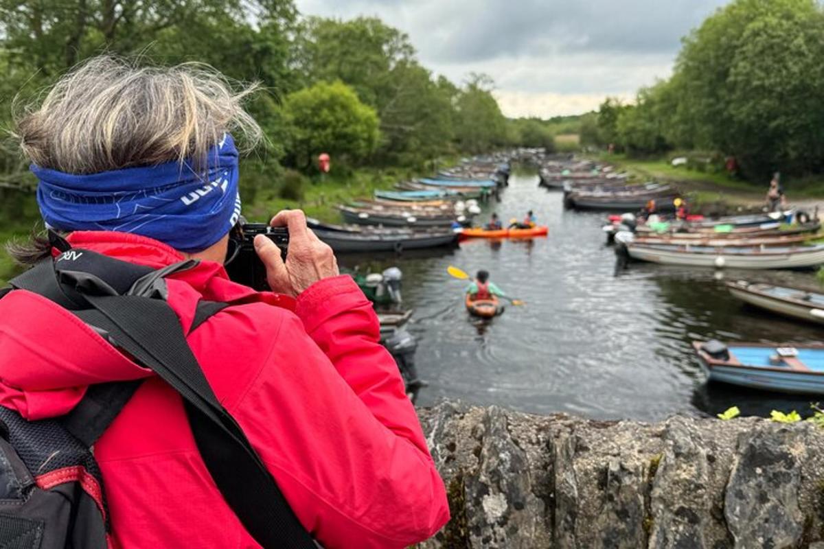 una persona tomando una fotografía de un río con barcos