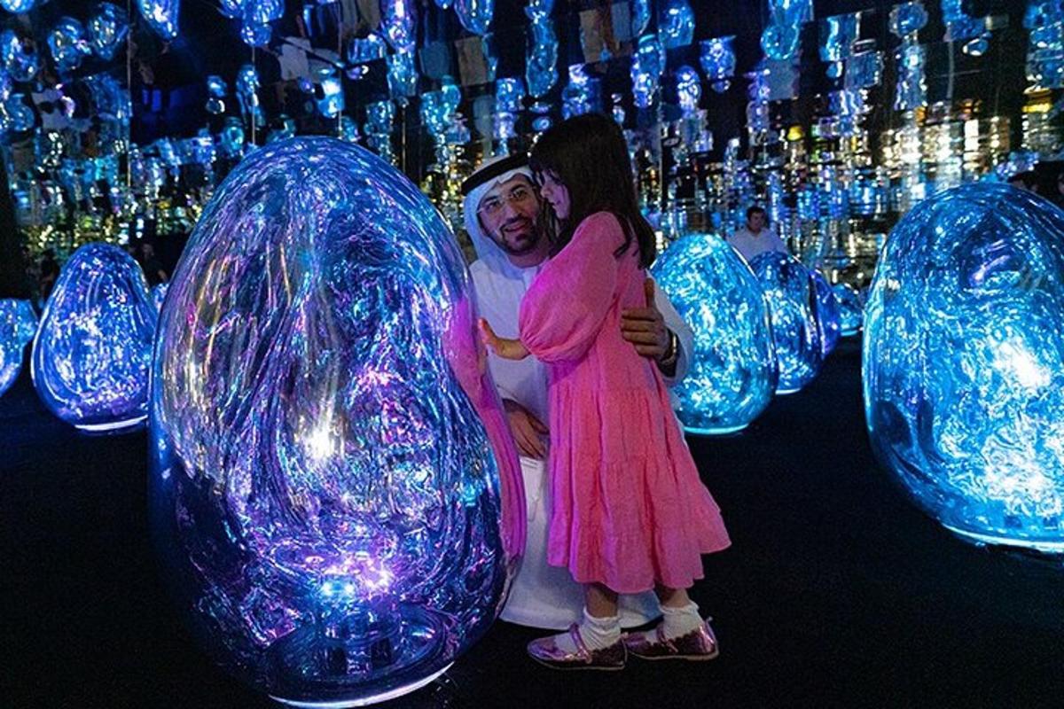 a man and a woman standing in front of blue glass orbs