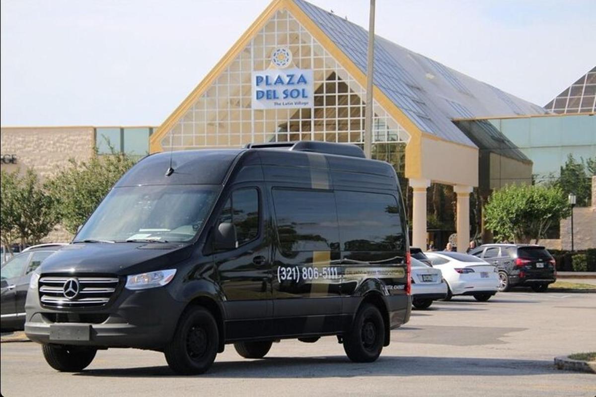 Una camioneta negra estacionada en un estacionamiento frente a un edificio.