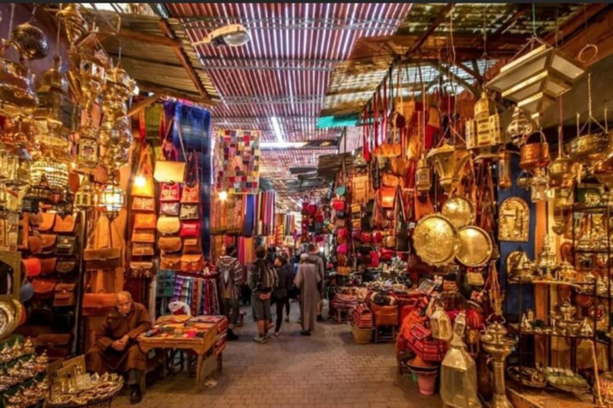 a group of people walking through a market with shops