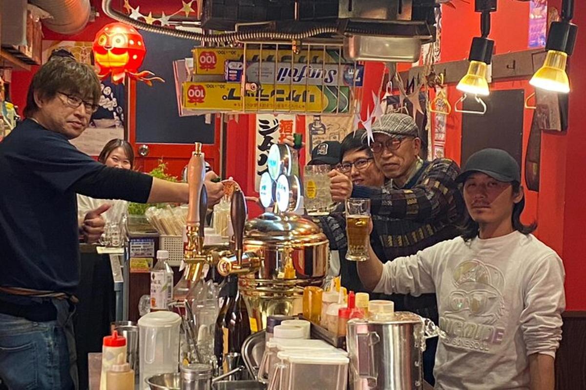 sekumpulan orang berdiri di sekeliling bar dengan pelayan bar