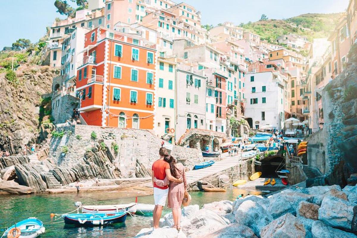 due persone in piedi sulle rocce vicino a un fiume con edifici