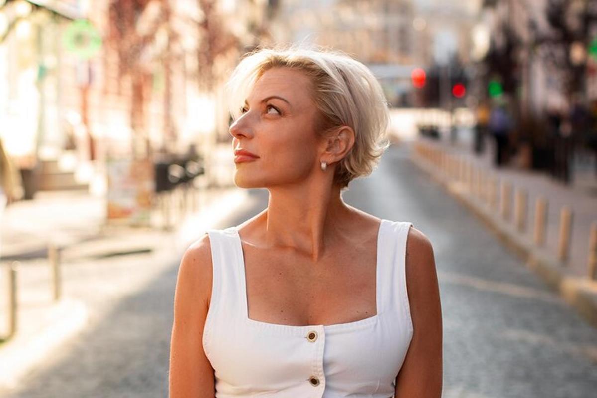 a woman in a white dress standing on a street