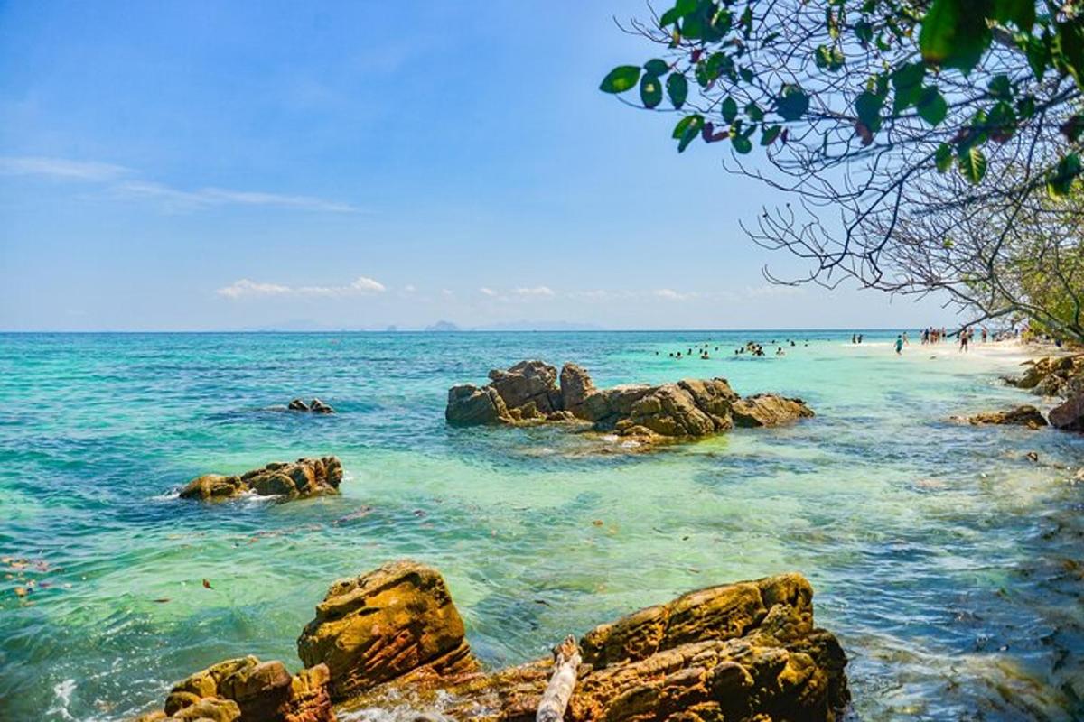 uma praia com pedras e pessoas na água