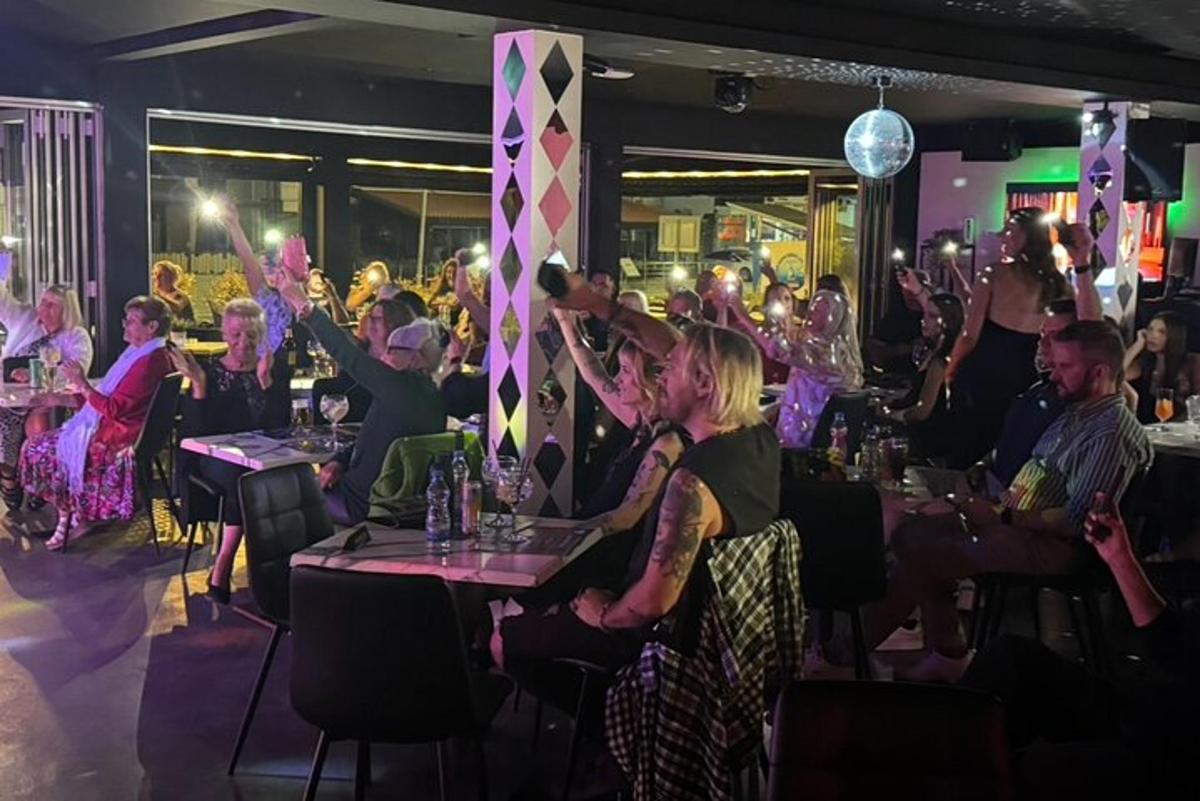 a crowd of people sitting at tables in a restaurant