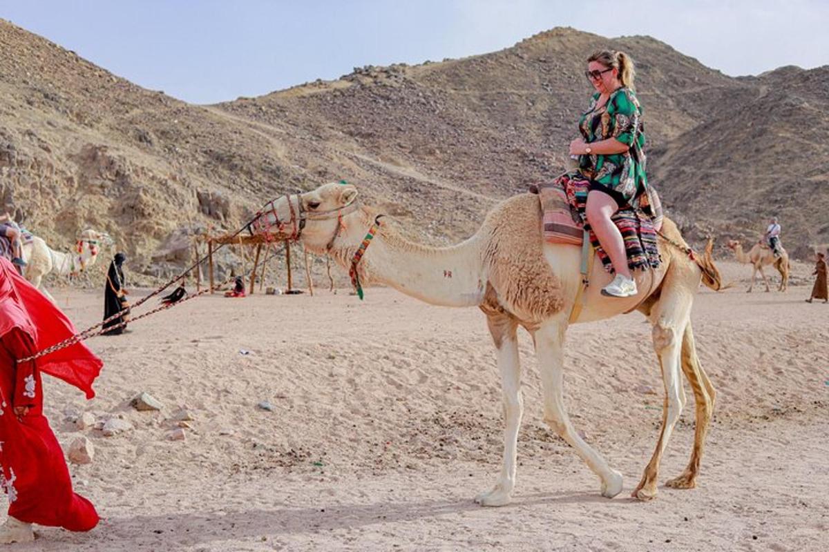 una donna a cavallo di un cammello nel deserto