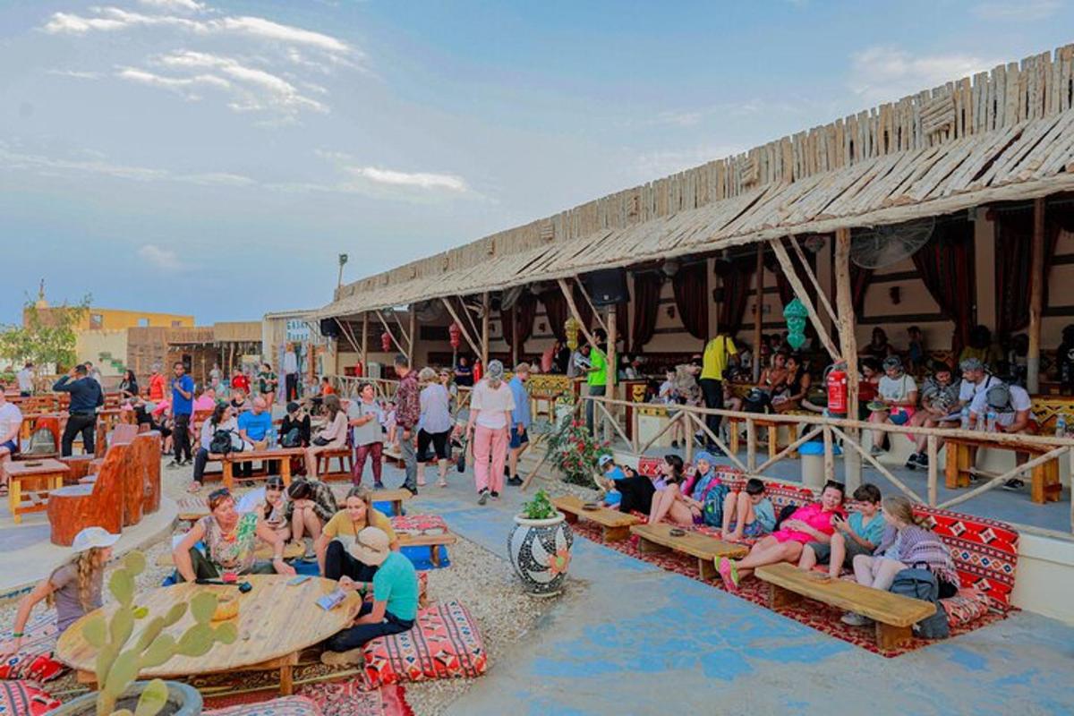 a large group of people sitting on benches on a beach