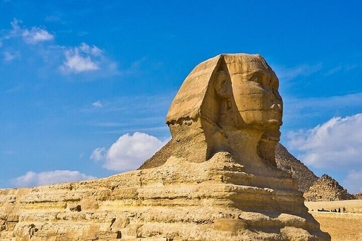 una estatua de Anubis frente a una pirámide