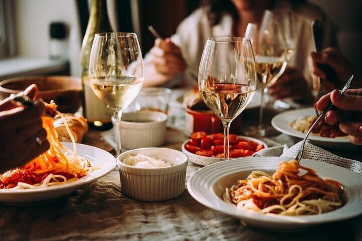 o masă cu farfurii de paste și pahare de vin