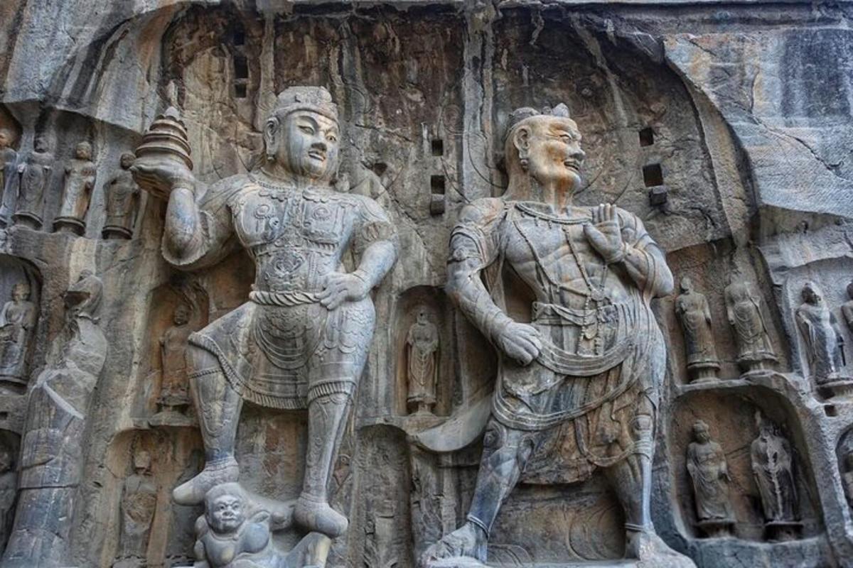 a stone sculpture of two men on the side of a building